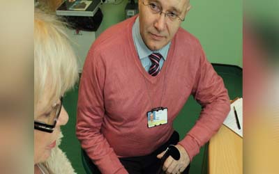 Eye Clinic Liaison Officer ECLO talking to a woman.leaflet.