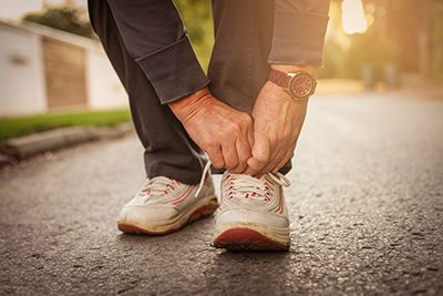 Man tying up the laces on his running shoes.