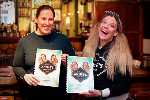 Annie from Annie's Burger Shack and a Member of My Sight Notts' staff with their new Braille Menus