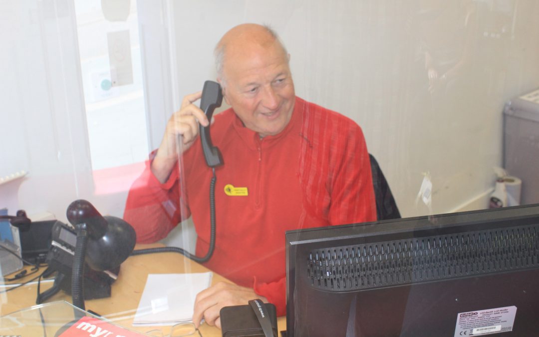 Man using telephone at desk in My Sight Nott's reception area