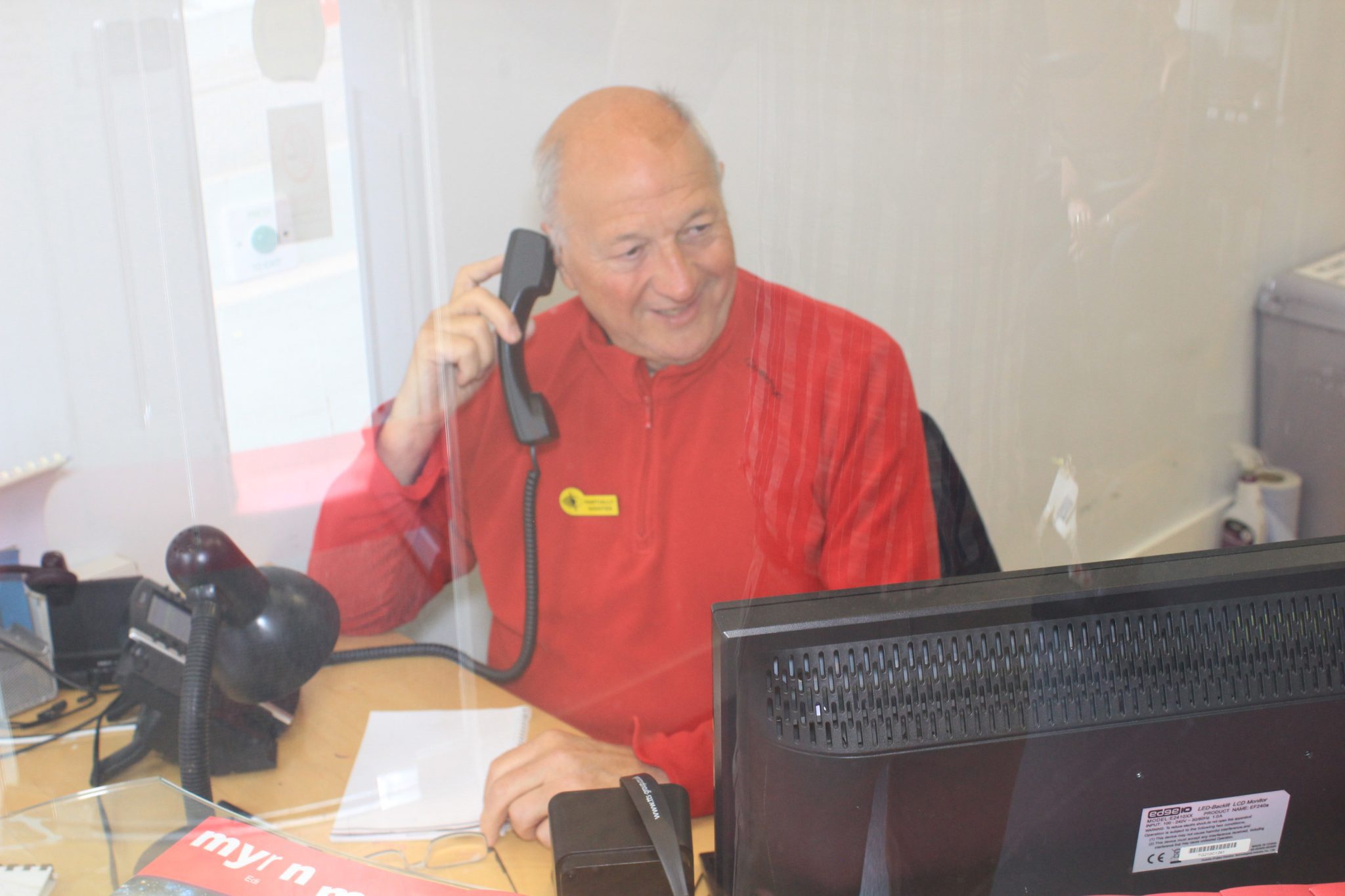 Man using telephone at desk in My Sight Nott's reception area